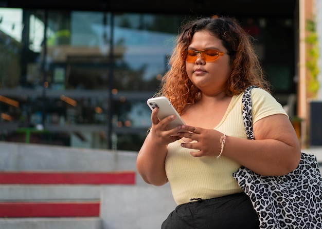 Femme de taille moyenne posant à l'extérieur