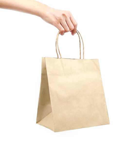Une femme tenant un sac en papier recyclé sur un fond blanc