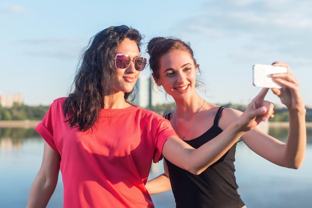 Femmes prenant une photo d'elle-même à la plage