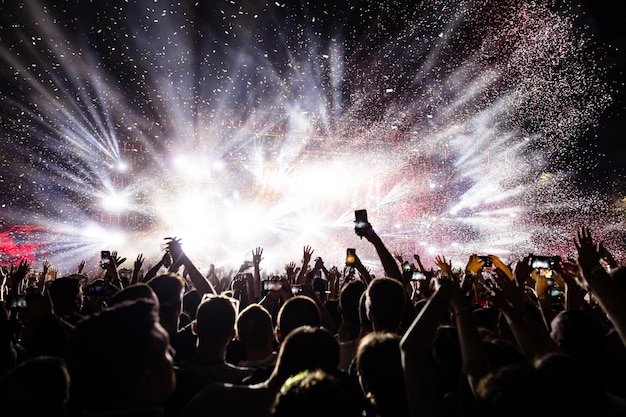 Photo des feux d'artifice en confetti au-dessus de la foule lors d'un festival de musique