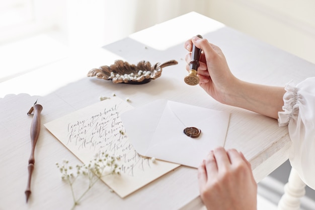 Photo fille écrit une lettre à son homme bien-aimé assis à la maison