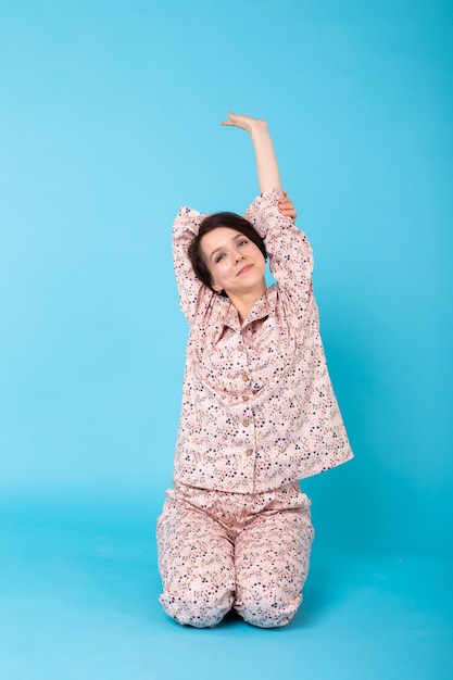 Photo girl in home wear pyjama s'amusant sur bleu