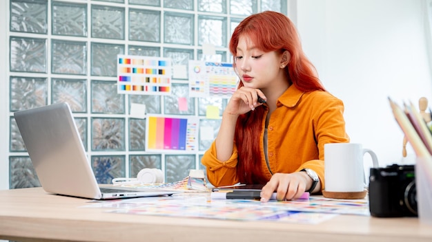 Photo un graphiste travaille en studio en se concentrant sur la sélection de couleurs à partir d'un ensemble de échantillons de couleurs