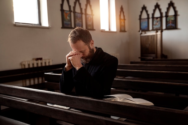 Gros plan sur le prêtre lisant la bible