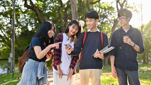 Un groupe d'étudiants asiatiques heureux aime parler et marcher ensemble dans le parc du campus