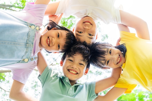 Photo un groupe de mignons enfants asiatiques s'amusant dans le parc.