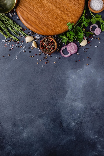 Photo herbes et condiments sur fond de pierre noire. vue de dessus avec espace de copie.