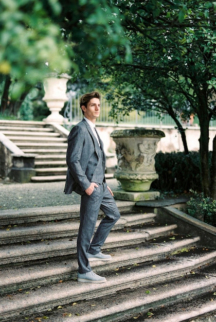 Homme en costume sur les marches de pierre dans le parc de Côme Italie