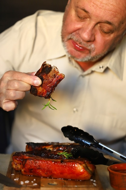 Homme mangeant de savoureuses côtes de porc