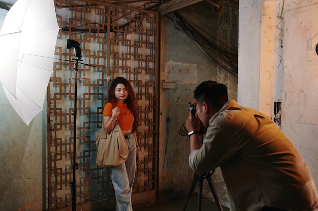 Un homme photographie une fille dans un vieil immeuble