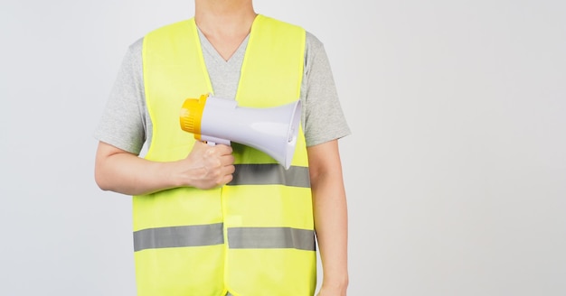 Photo un homme porte un gilet de sécurité et tient un mégaphone sur fond blanc