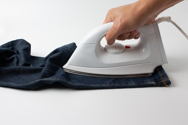 Homme, repassage, bleu, jeans, sur, table blanche, dans chambre