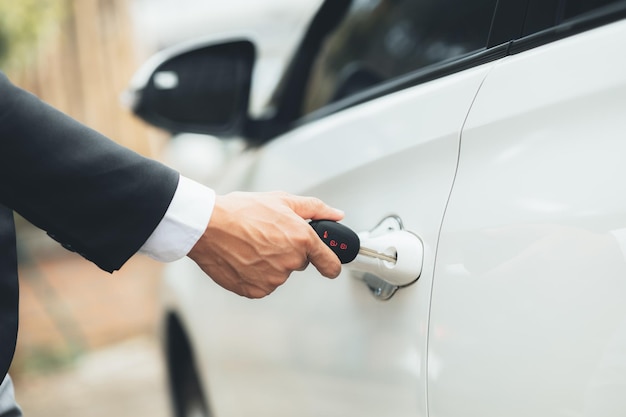 Homme utilisant des clés de voiture pour ouvrir les portes de voiture pour entrer pour se rendre au travail en utilisant des véhicules pour voyager en toute sécurité sur la route et en respectant les règles de circulation Concept de conduite de sécurité