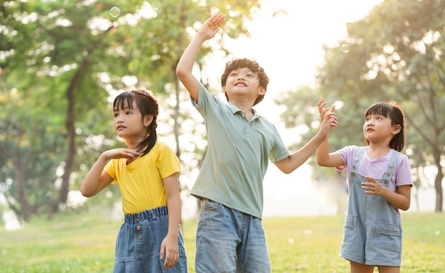 Photo image d'un groupe d'enfants asiatiques mignons jouant dans le parc