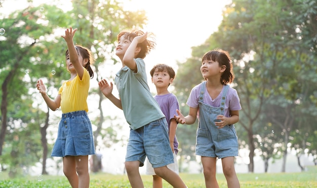 Photo image d'un groupe d'enfants asiatiques mignons jouant dans le parc