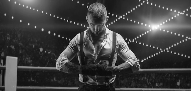 Image en noir et blanc d'un homme barbu en chemise blanche et bretelles dans le ring. Le concept de combats souterrains de poing. Technique mixte