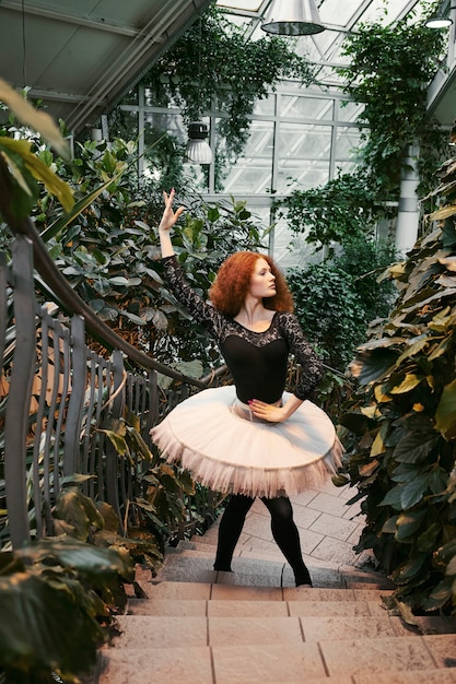 Jeune ballerine se produisant dans un jardin botanique intérieur