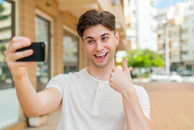 Photo jeune bel homme faisant un selfie avec un téléphone portable