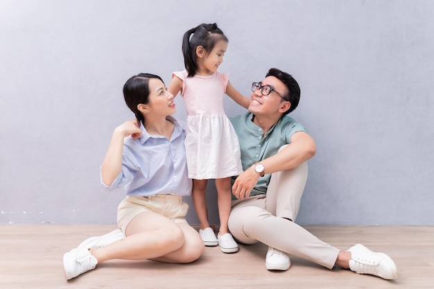 Jeune famille asiatique assise sur le sol