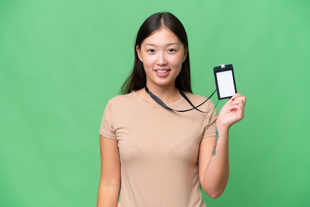 Jeune femme asiatique avec carte d'identité sur fond isolé souriant beaucoup