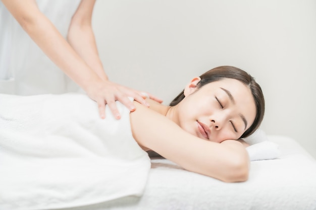 Photo jeune femme asiatique recevant un massage dans un salon d'esthétique