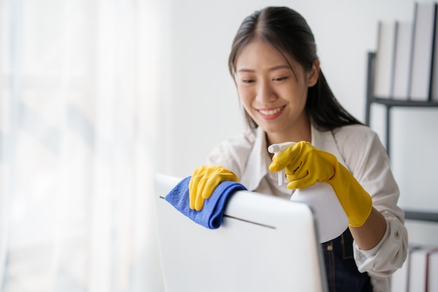 Photo jeune femme asiatique de service de nettoyage ouvrière nettoie la table à la maison belle jeune fille femme de ménage nettoyeuse se sent heureuse et essuyer désordre compteur sale pour le ménage ménage ou les tâches ménagères