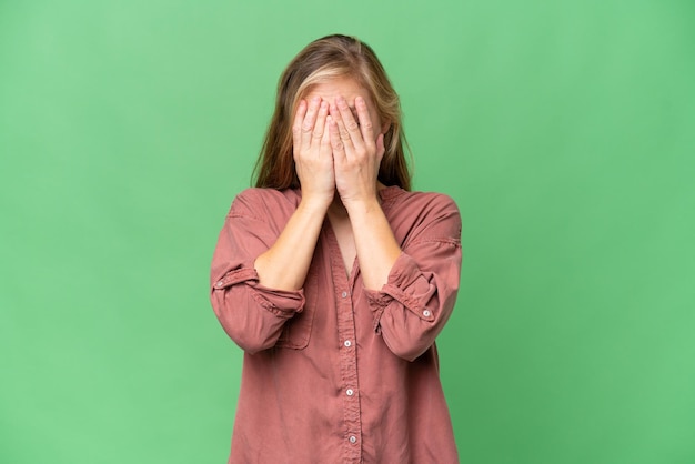 Jeune femme blonde sur fond isolé avec une expression fatiguée et malade