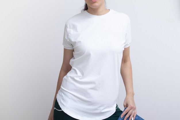 Une jeune femme est vêtue d'une maquette de t-shirt blanc vierge pour le dessin publicitaire d'inscriptions