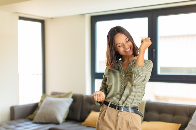 Photo jeune femme latine souriante, se sentir insouciante, détendue et heureuse, danser et écouter de la musique, s'amuser lors d'une fête