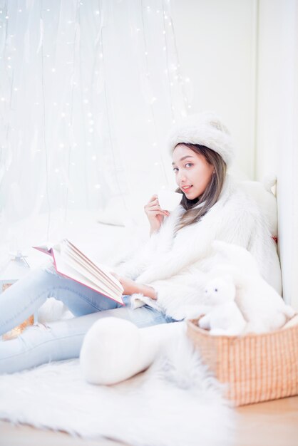 Jeune femme profitant de la saison d'hiver. Détente et style de vie pendant les vacances de Noël à la maison.