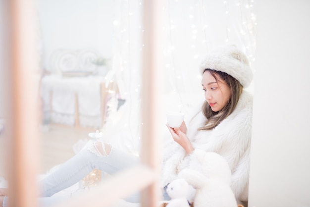 Jeune femme profitant de la saison d'hiver. Détente et style de vie pendant les vacances de Noël à la maison.