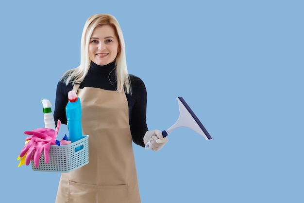 Jeune femme souriante plus propre. Isolé sur fond bleu.