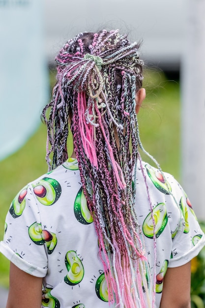 Photo jeune fille avec une coiffure à la mode : cheveux tressés avec des fils colorés tressés