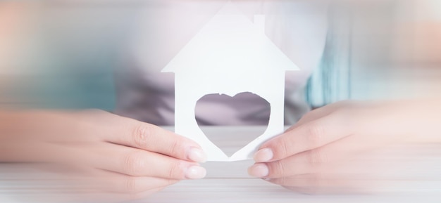 Jeune fille tenant une maison en forme de coeur