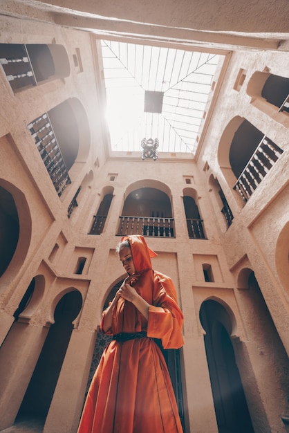 Photo une jeune fille en vêtements marocains se tient au milieu du temple. le plafond du temple est visible, vue de dessous