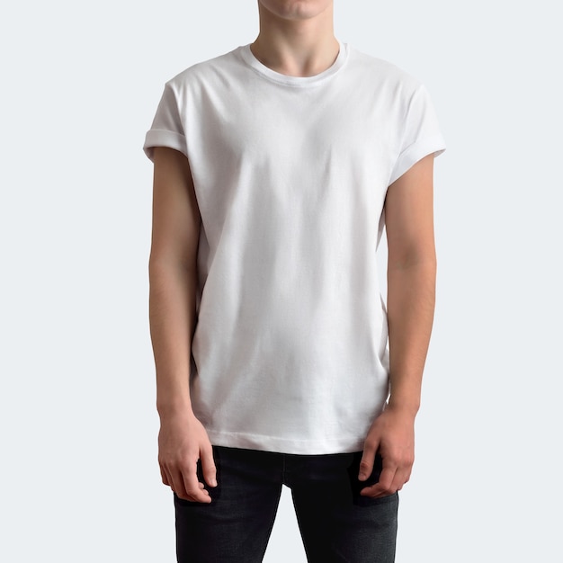 Jeune homme mince dans un T-shirt vierge et un jean noir sur fond de studio blanc. La maquette peut être utilisée dans votre vitrine.