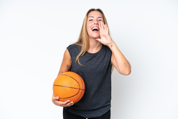 Jeune joueur caucasien de basket-ball femme isolée sur fond blanc criant avec la bouche grande ouverte