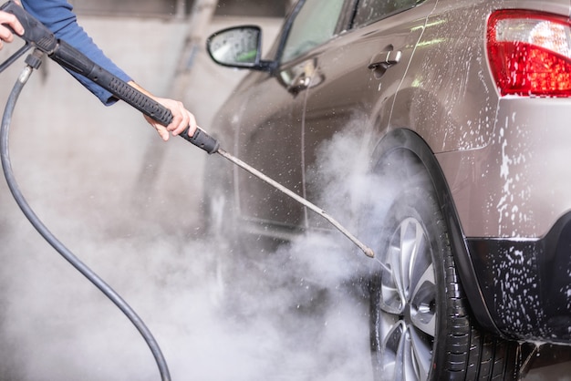 Lave-auto manuel à l&#39;eau sous pression dans un lave-auto à l&#39;extérieur.