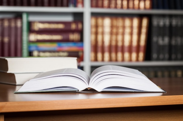 Livre ouvert sur la vieille table en bois au fond de la bibliothèque