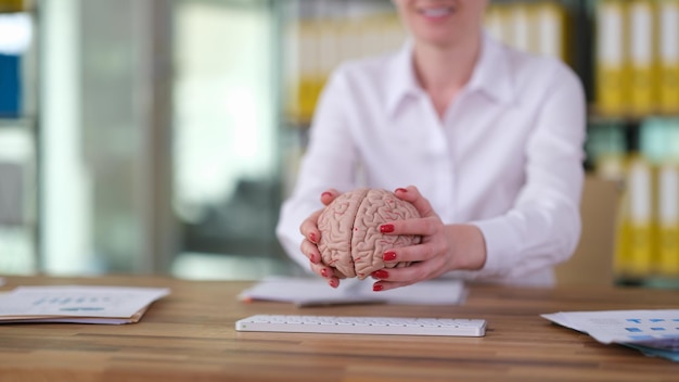 Mains féminines mettant le cerveau humain sur le clavier libre