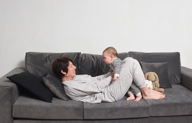 Mère qui joue avec son fils sur le canapé à la maison