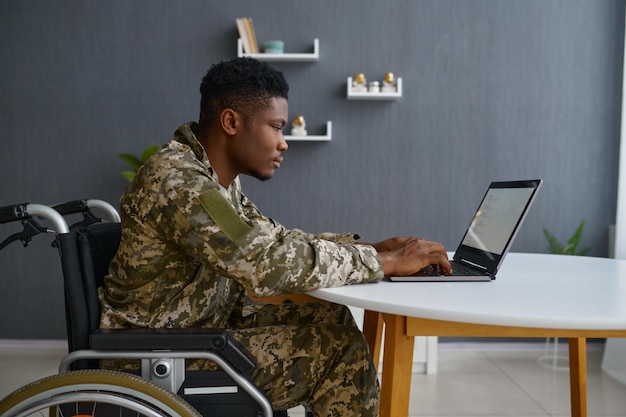 Militaire handicapé travaillant sur ordinateur portable