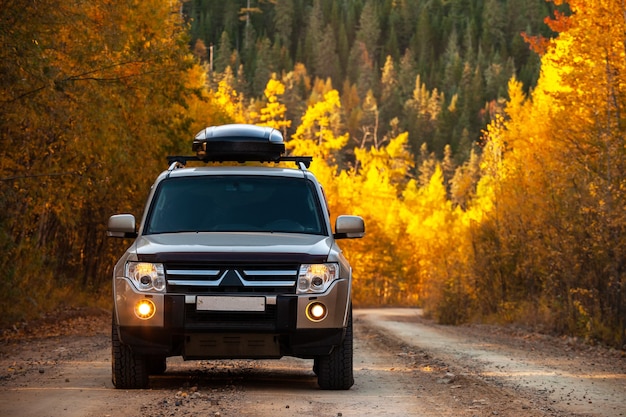 Photo mitsubishi pajero sur la route scénique d'automne dans la forêt magnifique