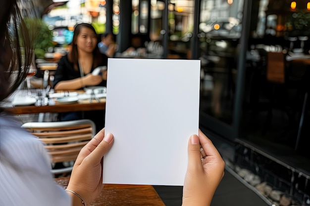 Photo mockup d'un menu vide dans les mains d'une femme contre un café ou un restaurant arrière-plan flou intérieur minimaliste blanc feuille de menu vide généré par l'ia