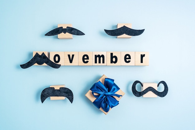 Photo mot movember et moustaches sur fond bleu