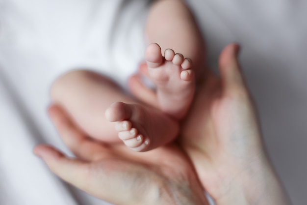 Parent tenant dans les mains les pieds du nouveau-né. Concept de famille, parentalité, maternité