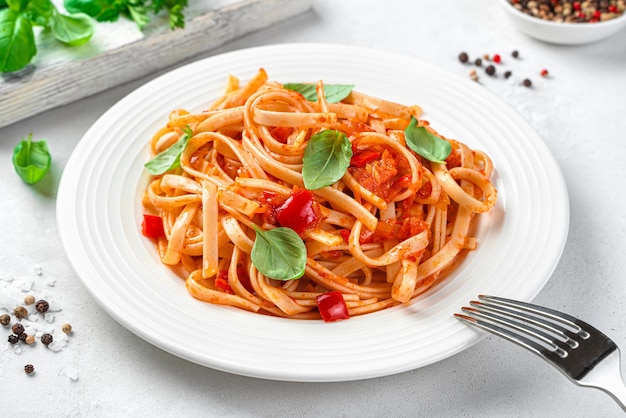 Pâtes italiennes classiques à la sauce tomate et basilic sur un gros plan de fond clair