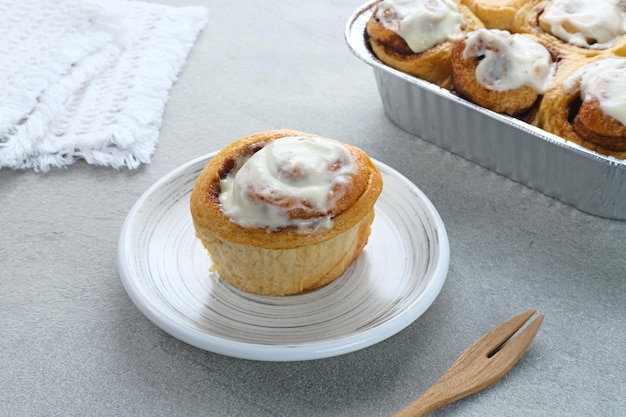 Pâtisserie de petits pains à la cannelle fraîche avec sauce à la crème à la vanille. Fermer.