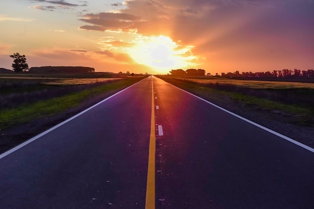 Paysage avec route et ciel orageux au coucher du soleil