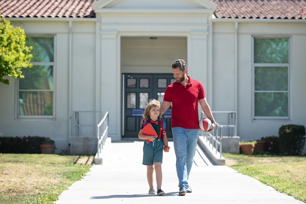 Père et fils garçon marchant près de l'école